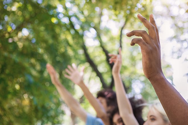 lots of hand in the air in a park
